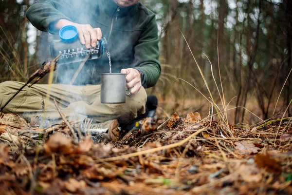 depositphotos_182640772-stock-photo-hunter-pours-water-from-a